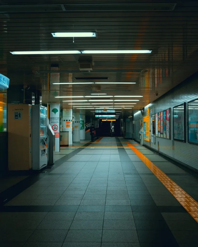 Empty subway station corridor with fluorescent lights.